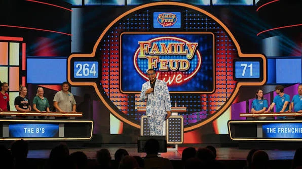 Family Feud LIVE production aboard Carnival Cruise Line with two families, host, gameboard, and contestant podiums