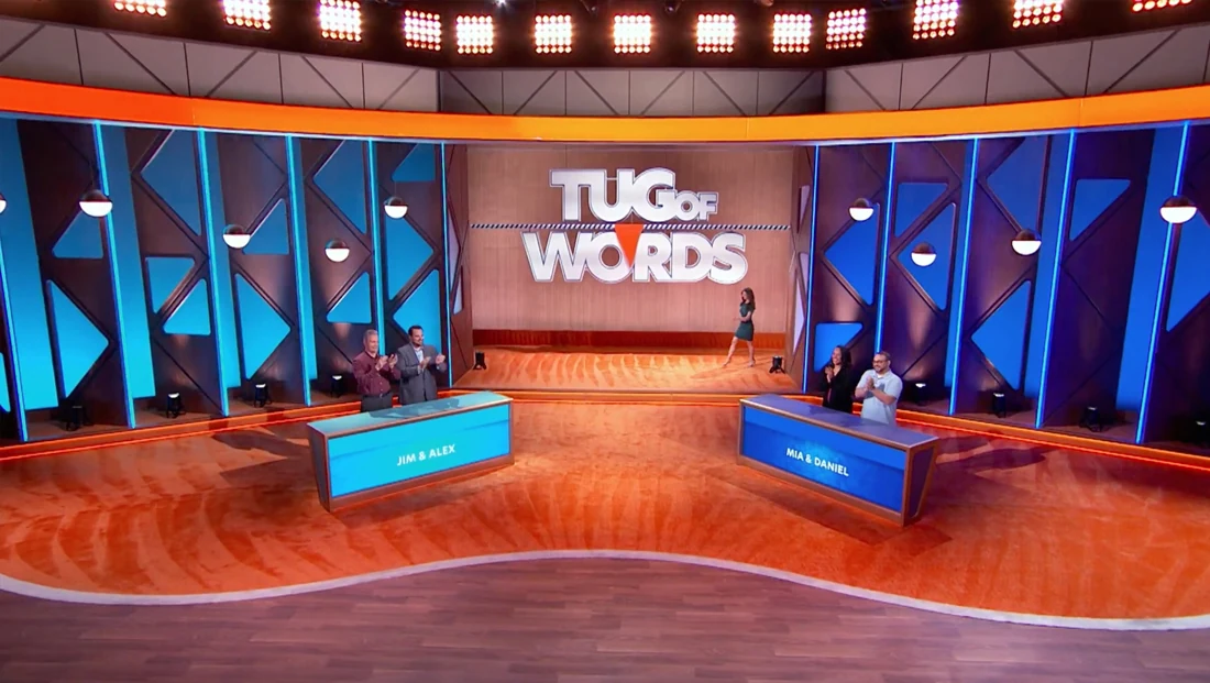 Tug of Words production set with contestant podiums and stage backdrop